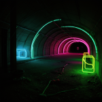 A vibrant underground tunnel illuminated with glowing neon lights, showcasing intricate designs and colorful pathways, creating an enchanting visual experience.