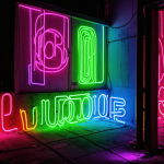 A vibrant neon graffiti mural on a wall, featuring glowing paint and dynamic colors, showcasing the fusion of urban art and illumination.