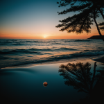 A mesmerizing view of a planet reflecting in the ocean during a colorful sunset, showcasing the harmonious blend of cosmic and terrestrial beauty.