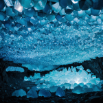 A mesmerizing view of a crystal cave glowing with vibrant blue hues, showcasing natural beauty and geological wonders.