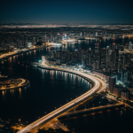 A breathtaking aerial view of a city illuminated by vibrant lights at night, showcasing the intricate urban landscape and stunning skyline.