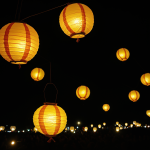 A beautiful display of paper lanterns glowing warmly against the night sky, casting a magical and serene ambiance perfect for evening gatherings.