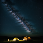 A picturesque tent set up under the vivid, starry expanse of the Milky Way galaxy, perfect for an inspiring night of camping and stargazing.