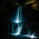An enchanting waterfall with a mystical glow, surrounded by lush greenery, capturing the magical essence and natural beauty of this stunning landscape.