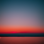 A breathtaking view of a gradient sunset horizon, showcasing vibrant shades of orange, pink, and purple as the sun sets, creating a tranquil and inspiring scene.