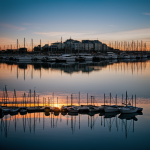 A breathtaking view of harbor sunset reflections with vibrant colors dancing on the water, creating a serene and dreamy atmosphere for nature lovers.