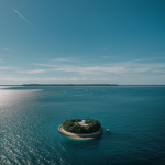 A breathtaking view of a lonely island surrounded by the vast sea, depicting serene isolation and untouched natural beauty.