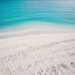 A breathtaking view of a white sand beach with crystal clear turquoise water, perfect for a relaxing tropical getaway and beach exploration.